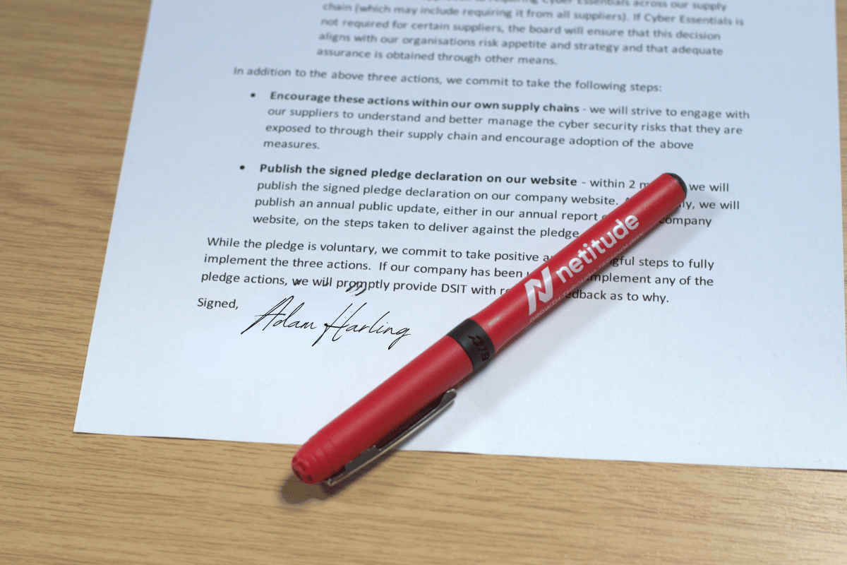 Netitude's signed Cyber Resilience Pledge declaration document with a branded Netitude pen