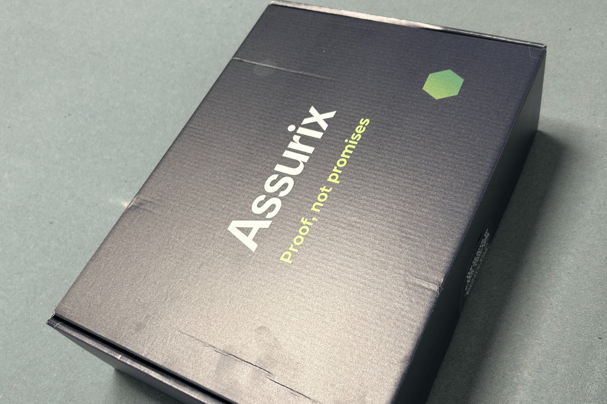 Assurix welcome box containing branded items and a personalized message, presented to Netitude as part of its founding member recognition.