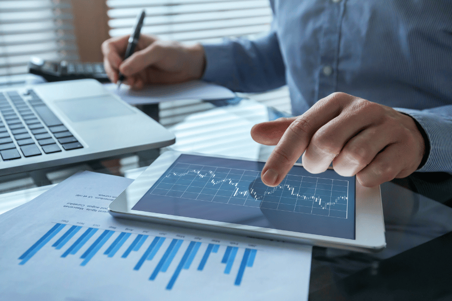 Person working in financial services running numbers and writing down figures.