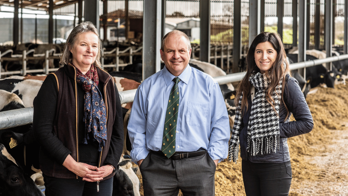 Photo of Pat Tomlinson with his fellow employees with what appears to be a farming backdrop.