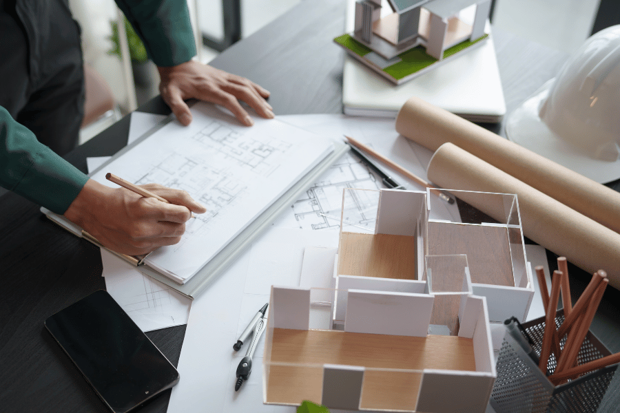 Person working in architectural services writing down floorplans and housing designs.