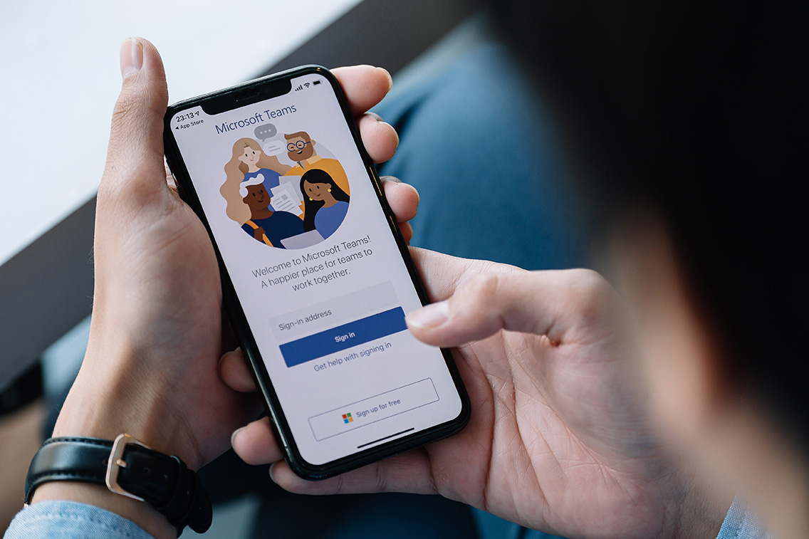 A working from home employee is downloading the Microsoft Teams social platform, ready for remote working in isolation from home