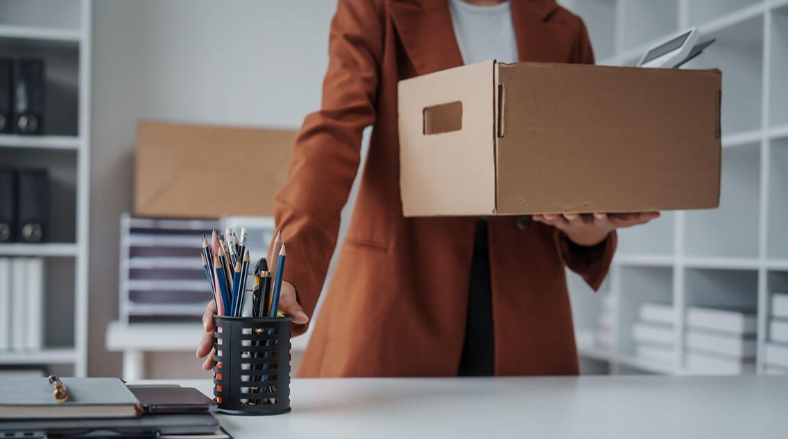 business woman carrying her personal stuff in a box.