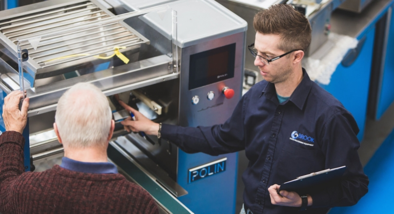 Brook Food employee showing a piece of equiptment to a new client