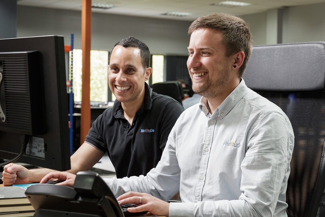 Two engineers working at a computer together