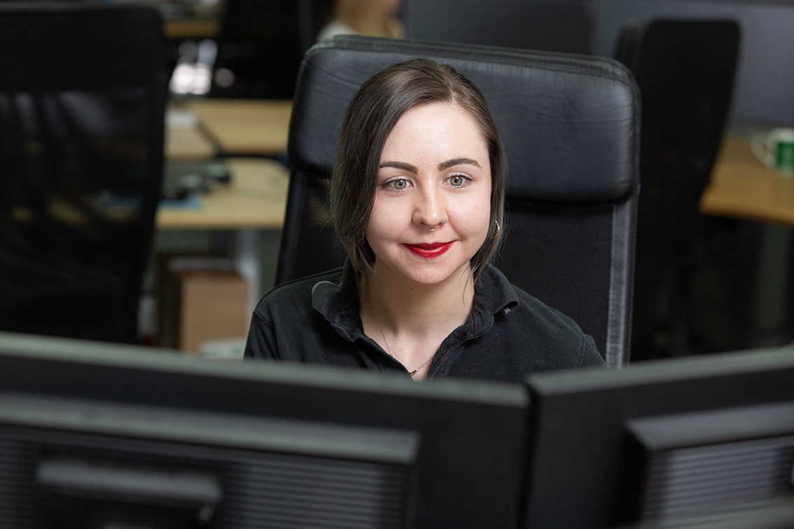 Customer Service Manager working at her desk, looking at the screens