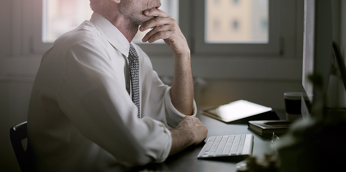 Man sitting at his computer thinking