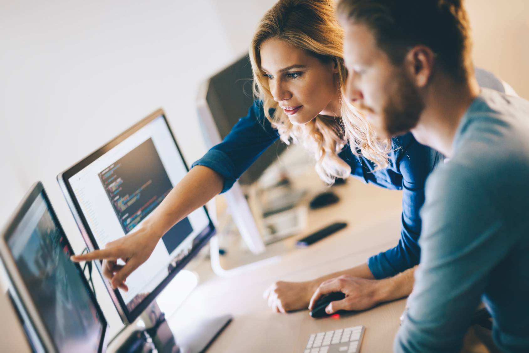 two staff memebers working at a computer together