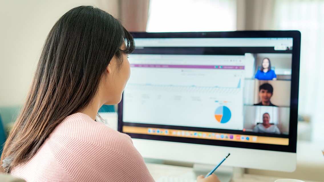 Woman joining a video call with team mates, while working.