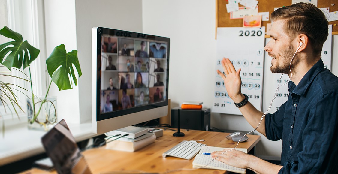 Young man having Zoom video call via a computer in the home office.