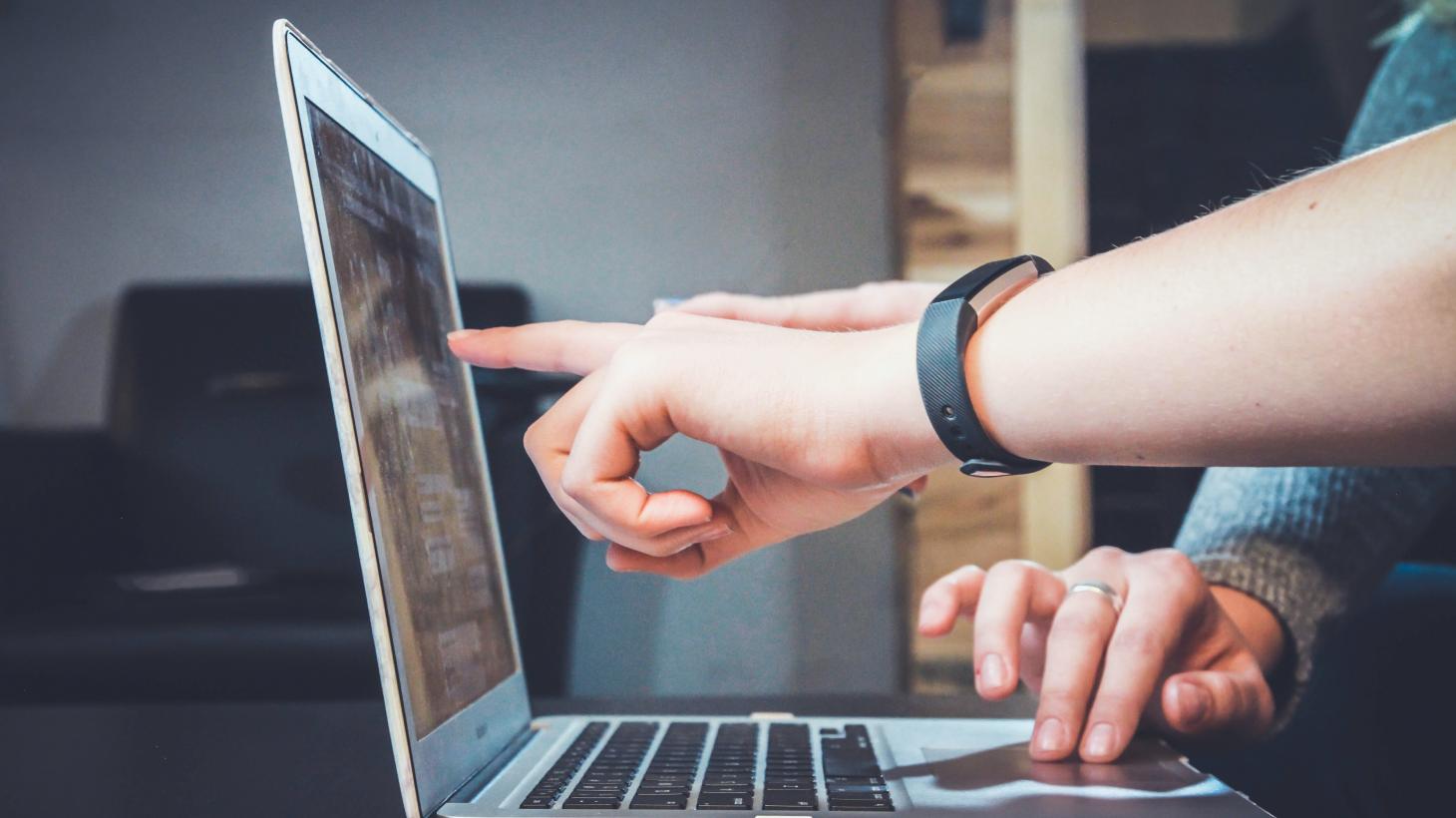 Two people working at a laptop