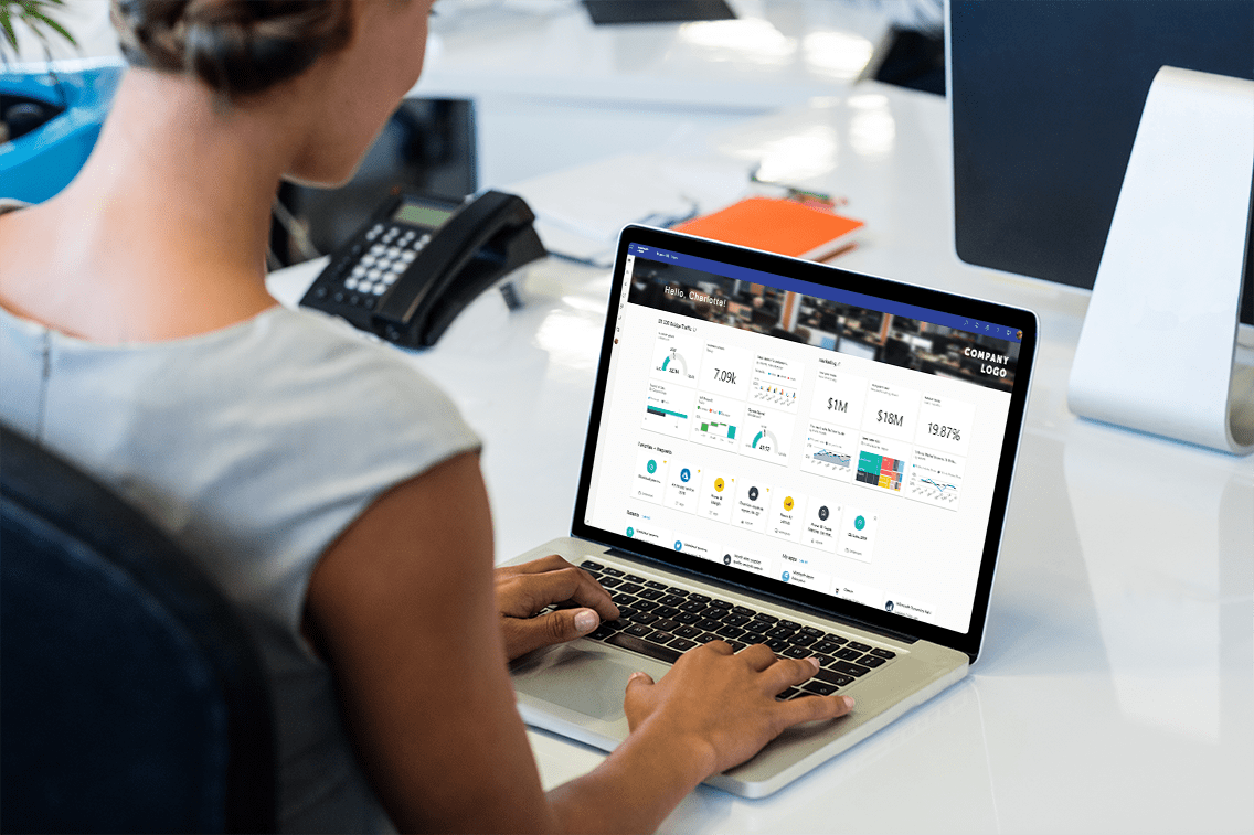 Woman looking at her Power BI dashboard on her lapop