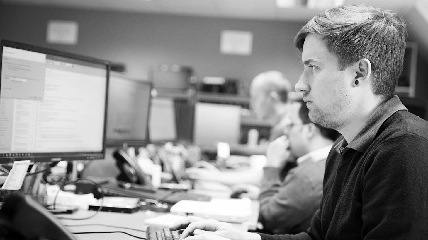 Male service engineers working at their computers