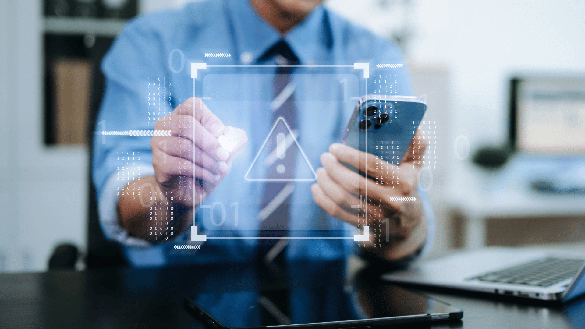 usiness professional holding a smartphone with a digital warning icon overlay, representing AI‑driven vishing and voice phishing threats.