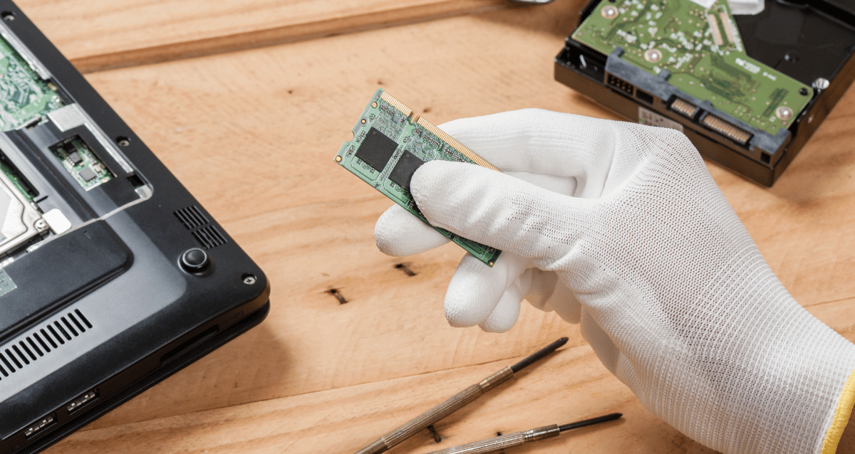 Image of a white glove holding a piece of technology. 