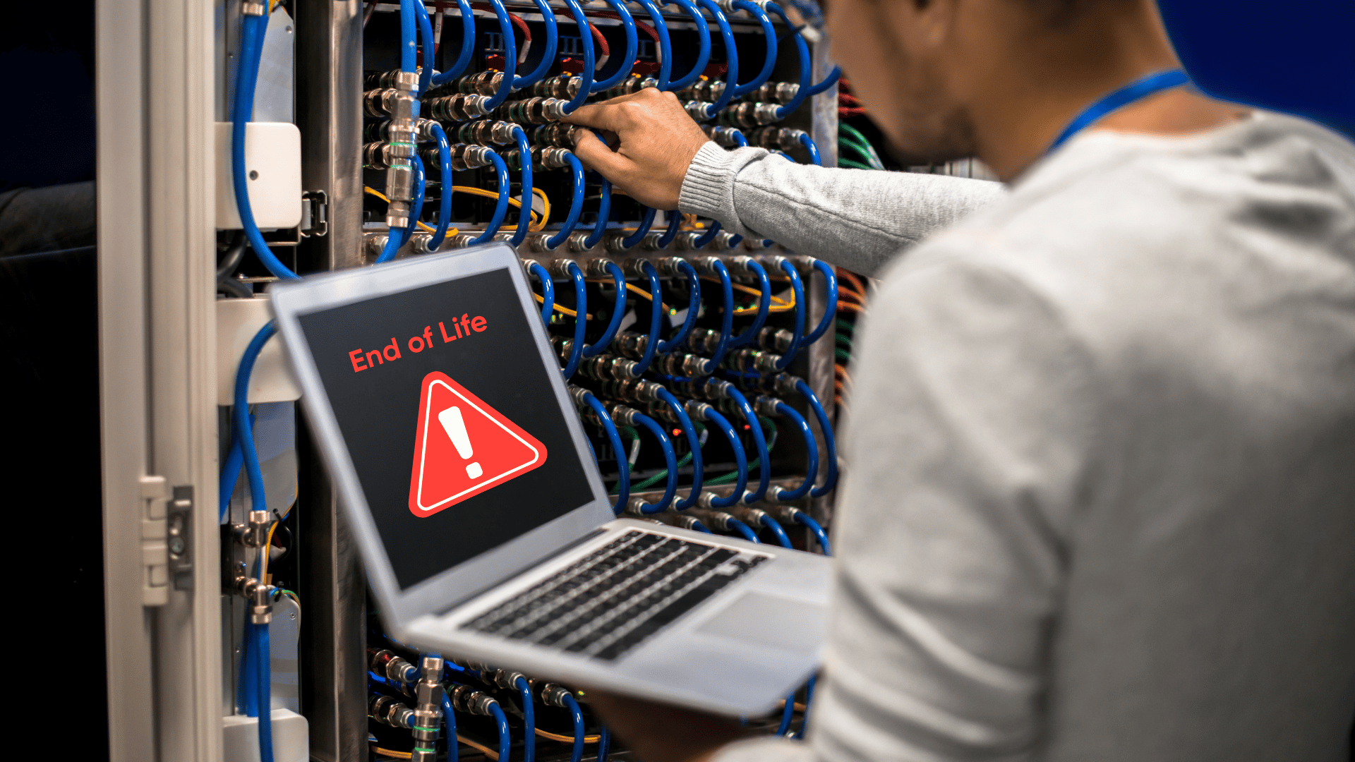 Engineer working on a server rack with a laptop displaying an 