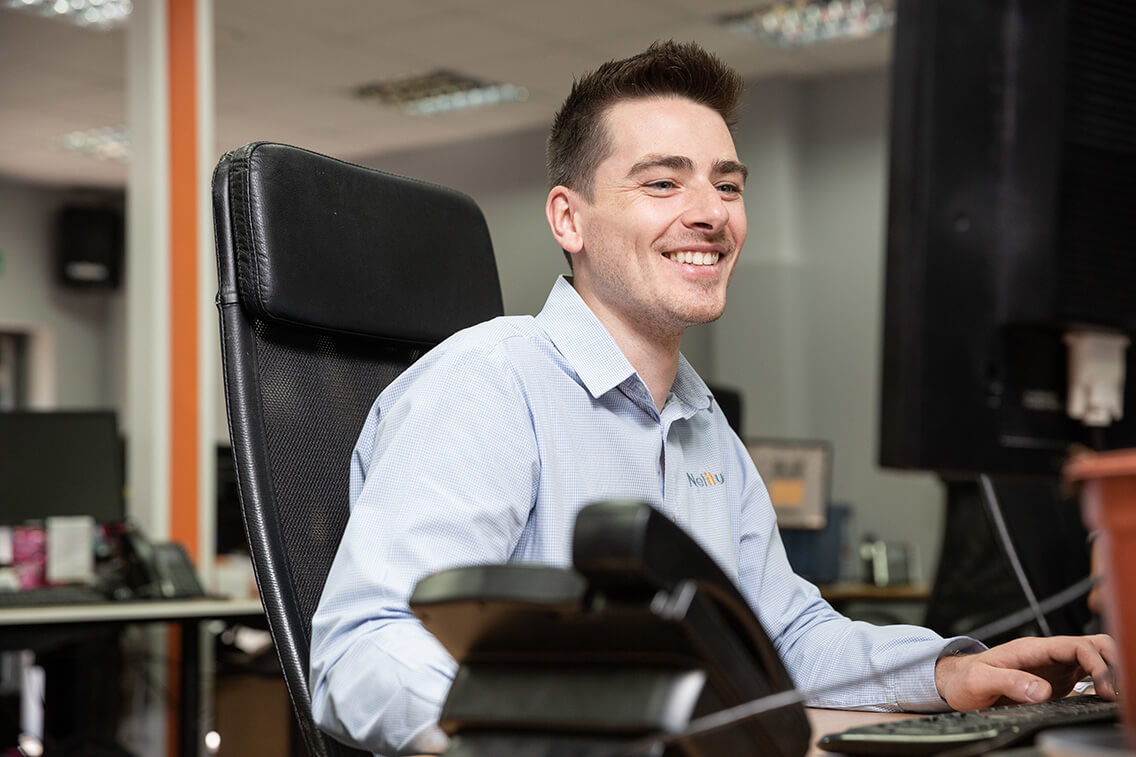 Technical Alignment Engineer, smiling while working at his computer