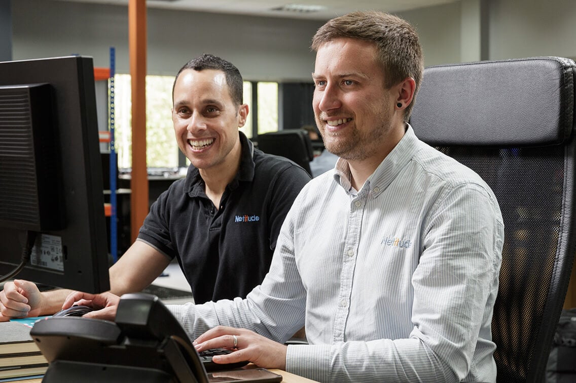 Two engineers working at a computer together