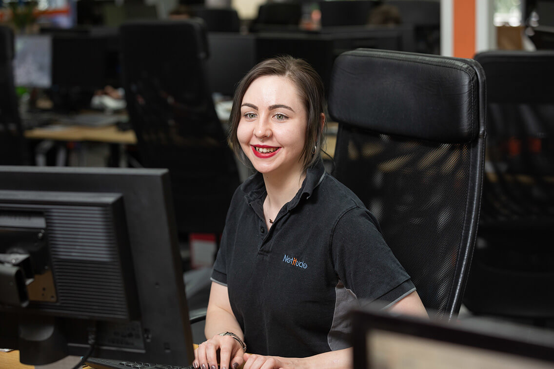 Customer Service Manager smiling while working at her computer