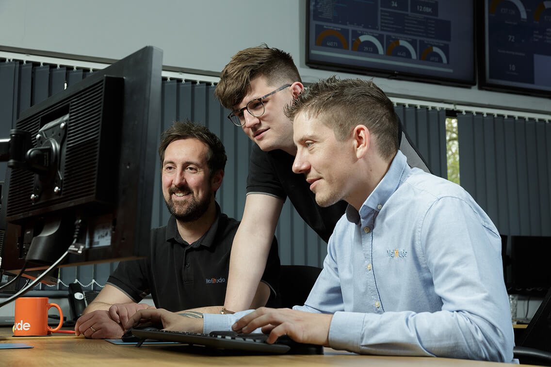 three male project engineers working at a computer together