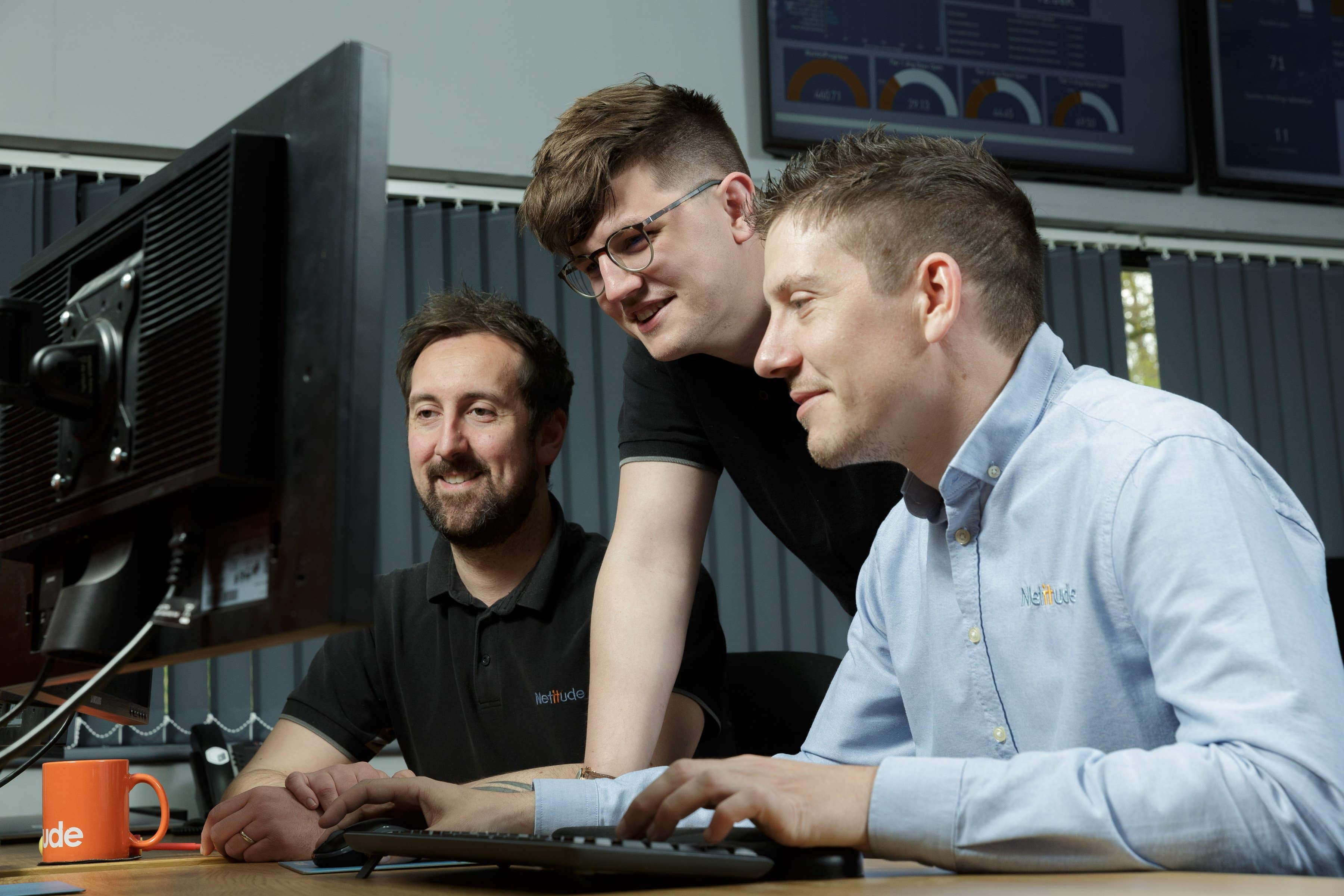 Three male project engineers working at a computer together