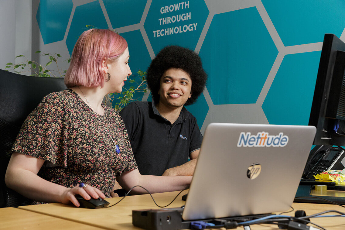 Female and male service desk engineers working together at a computer
